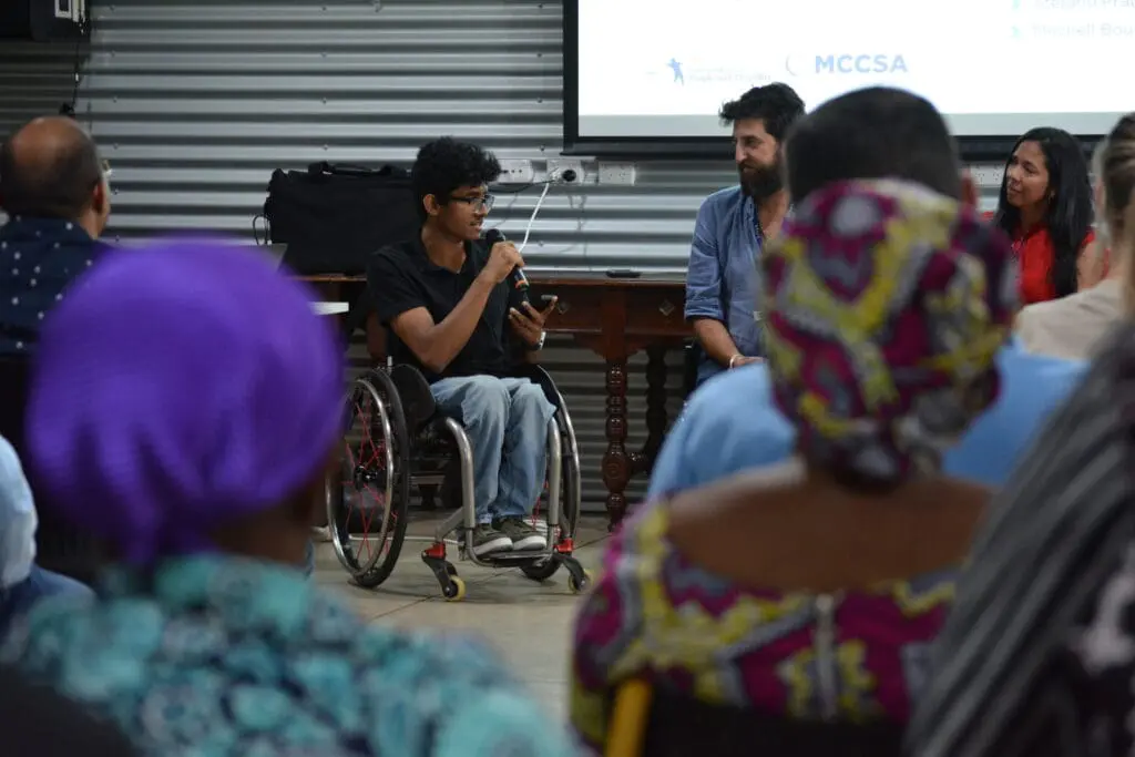 young man in wheelchair hosting a panel discussion at an event