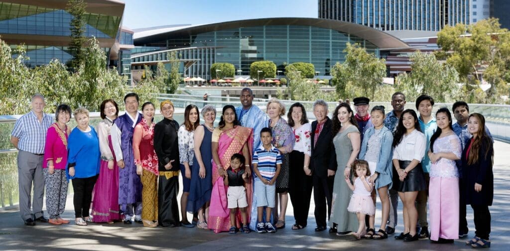 group of people in cultural dress in front of iconic SA buildings